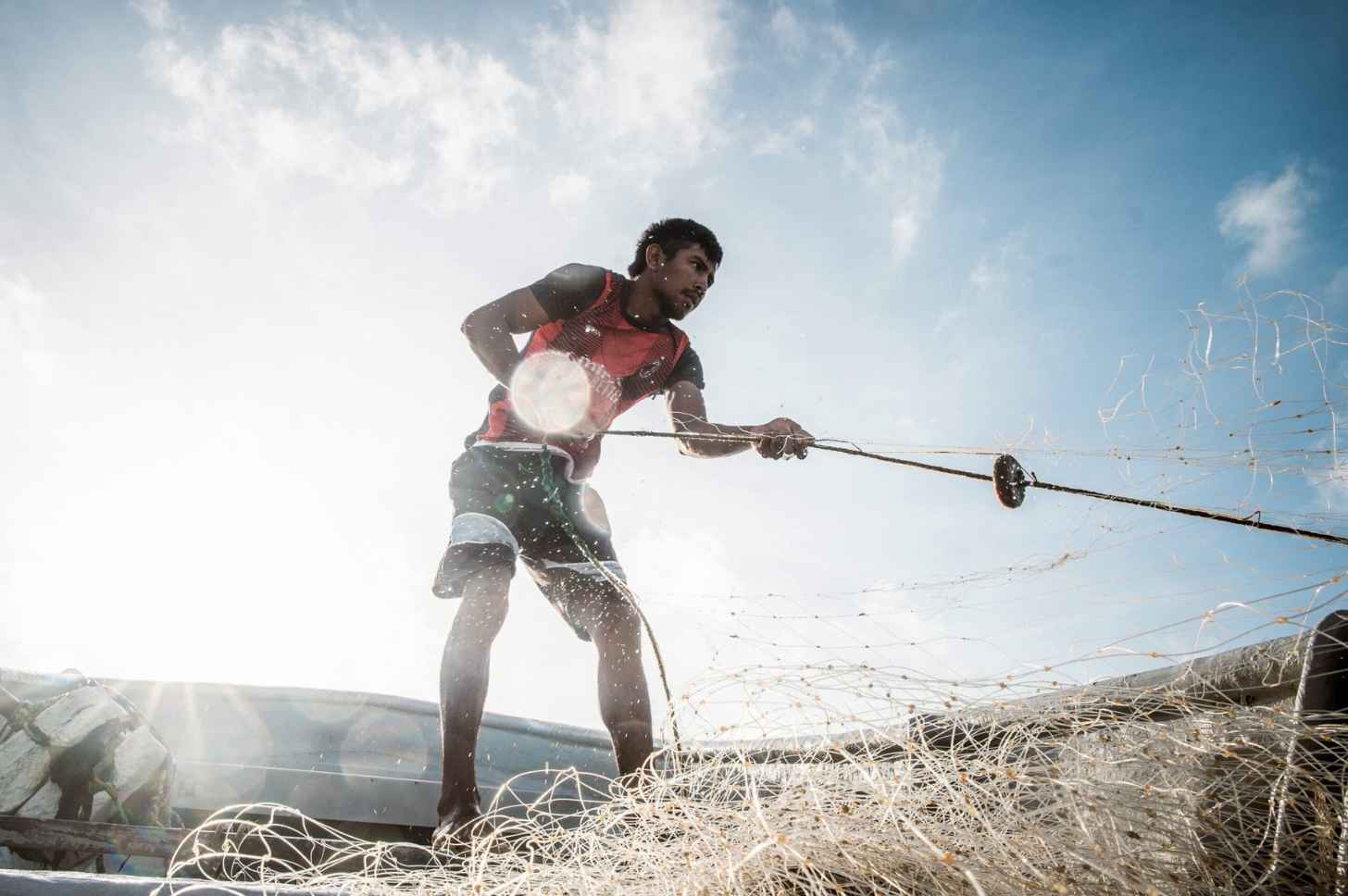Wilfrido Arends’ 22-year-old son, known as “Caraquitas” (“Little Caracas”) after his father, hauls a fishing net into the boat.