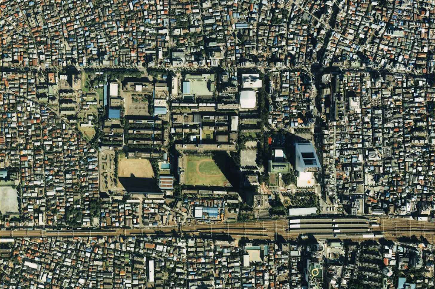 An aerial view of Tokyo, Japan, in 1989 showcases the large amount of surface area taken up by rooftops in urban environments. Widespread implementation of water tank sprinkler systems could put that surface area to good use to diminish urban heat island impacts.