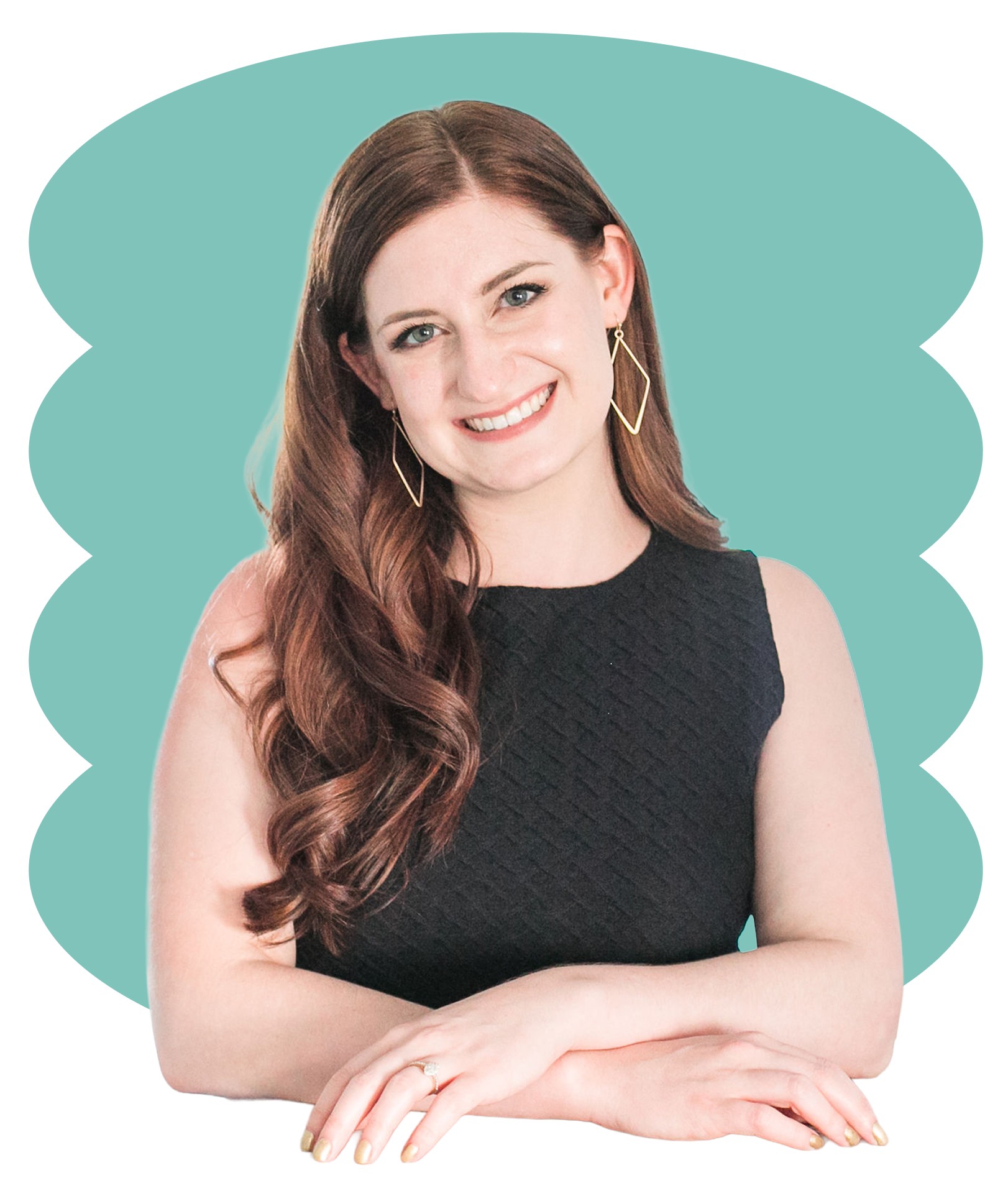 Smiling woman with long wavy auburn hair wearing a sleeveless black top and geometric earrings, posed with arms crossed.
