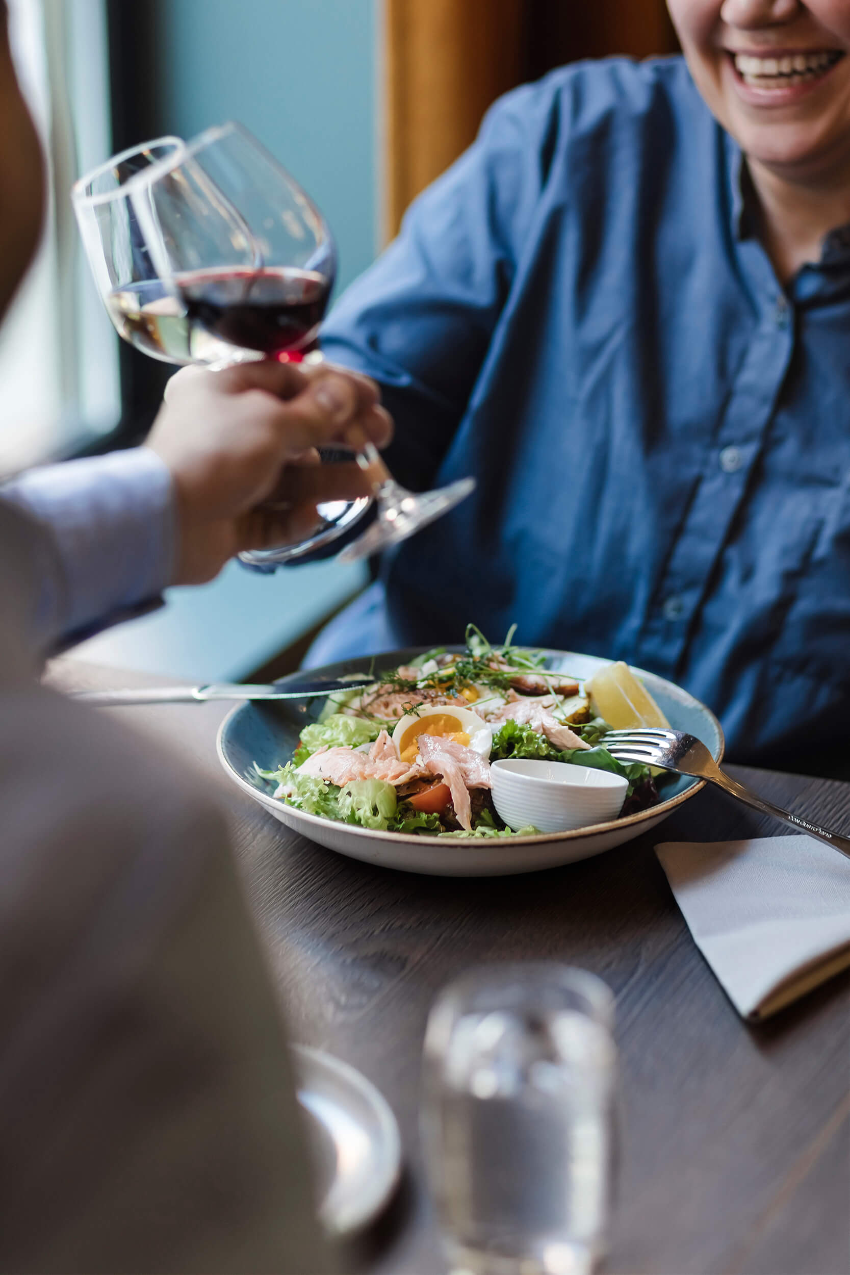 Skålar med vin ved bord.
Wine toast at table.