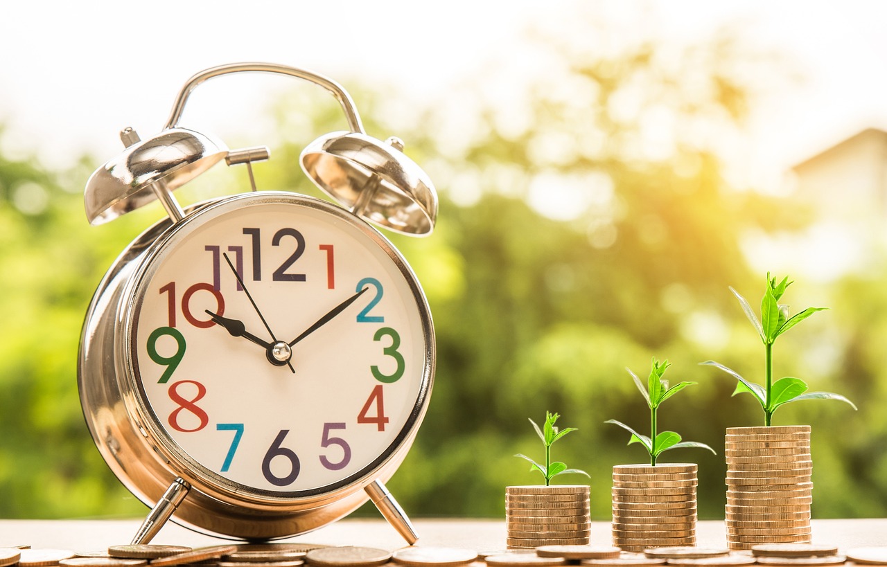 A clock next to a growing stack of coins representing repayment‍