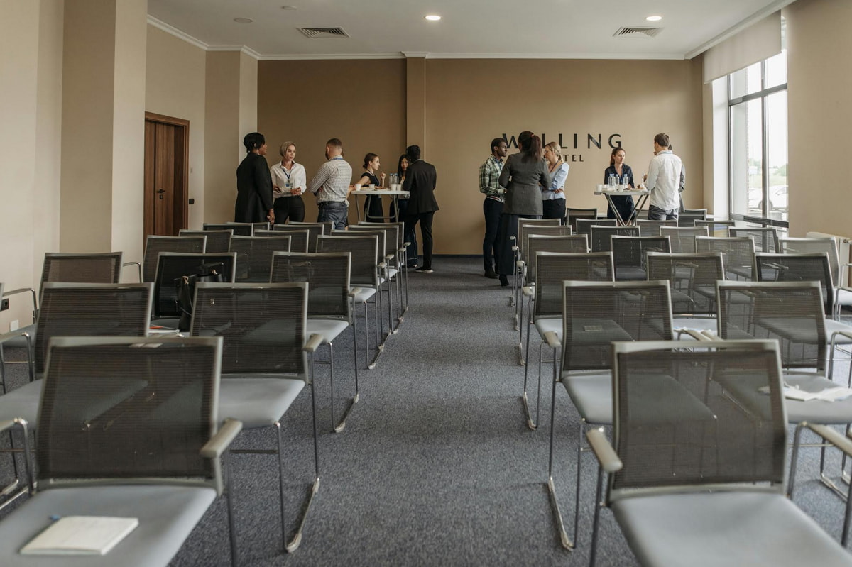A conference room featuring several chairs arranged around tables, designed for meetings and discussions.