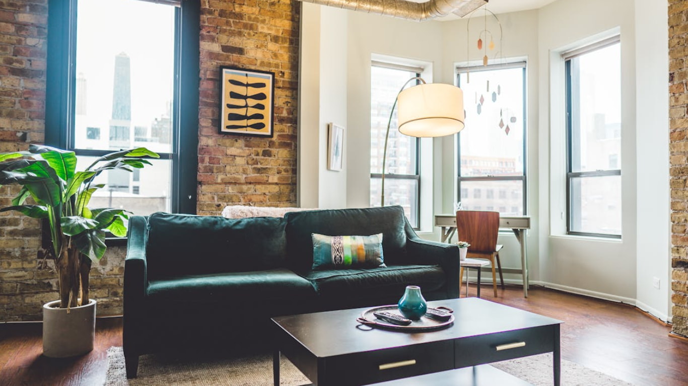 A cozy living room featuring exposed brick walls and a comfortable couch, creating a warm and inviting atmosphere. 