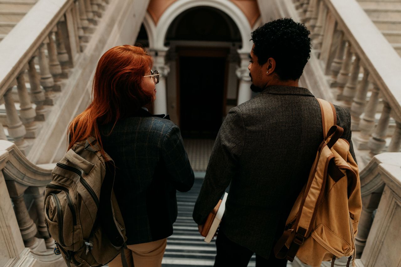 two students discussing their FAFSA awards walking down a set of stairs at their university