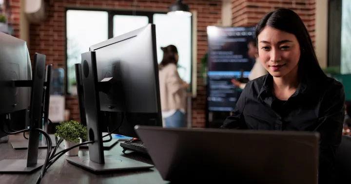 A woman sitting in front of a computer monitor.