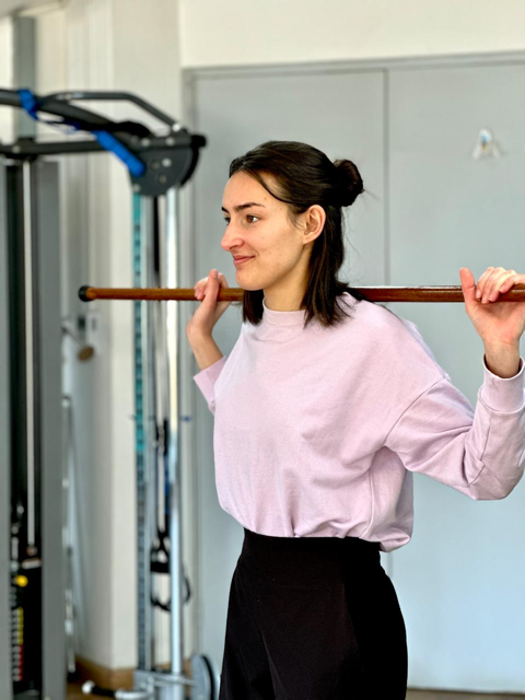 Charlene holding a stick in a gym.