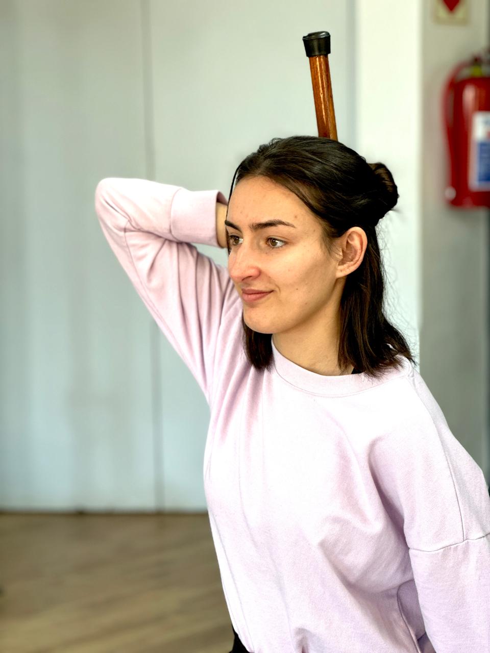 Charlene holding a stick over her head.