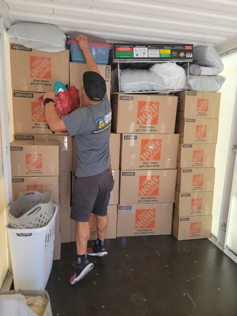 Lunardi Moving crew member loading a truck with organized labeled boxes and protected items