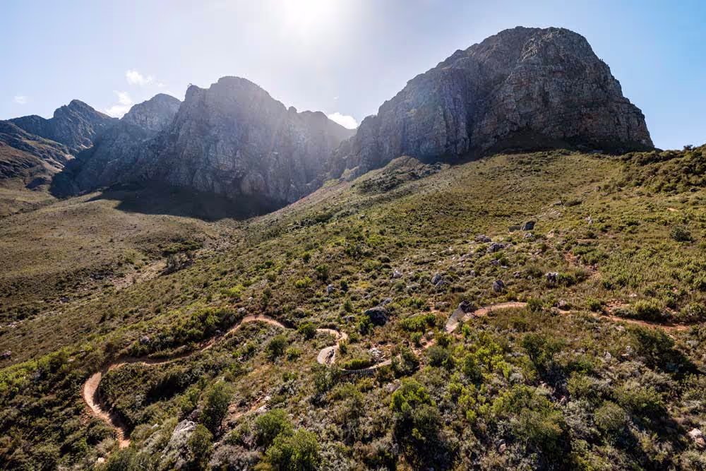 Winding hiking trail through rocky mountain landscape with rugged peaks