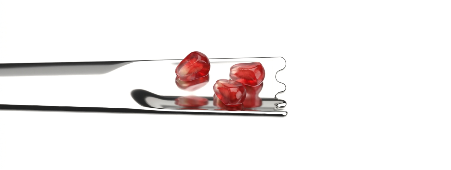Close-up of Stampy cocktail spoon with pomegranate seeds in it.