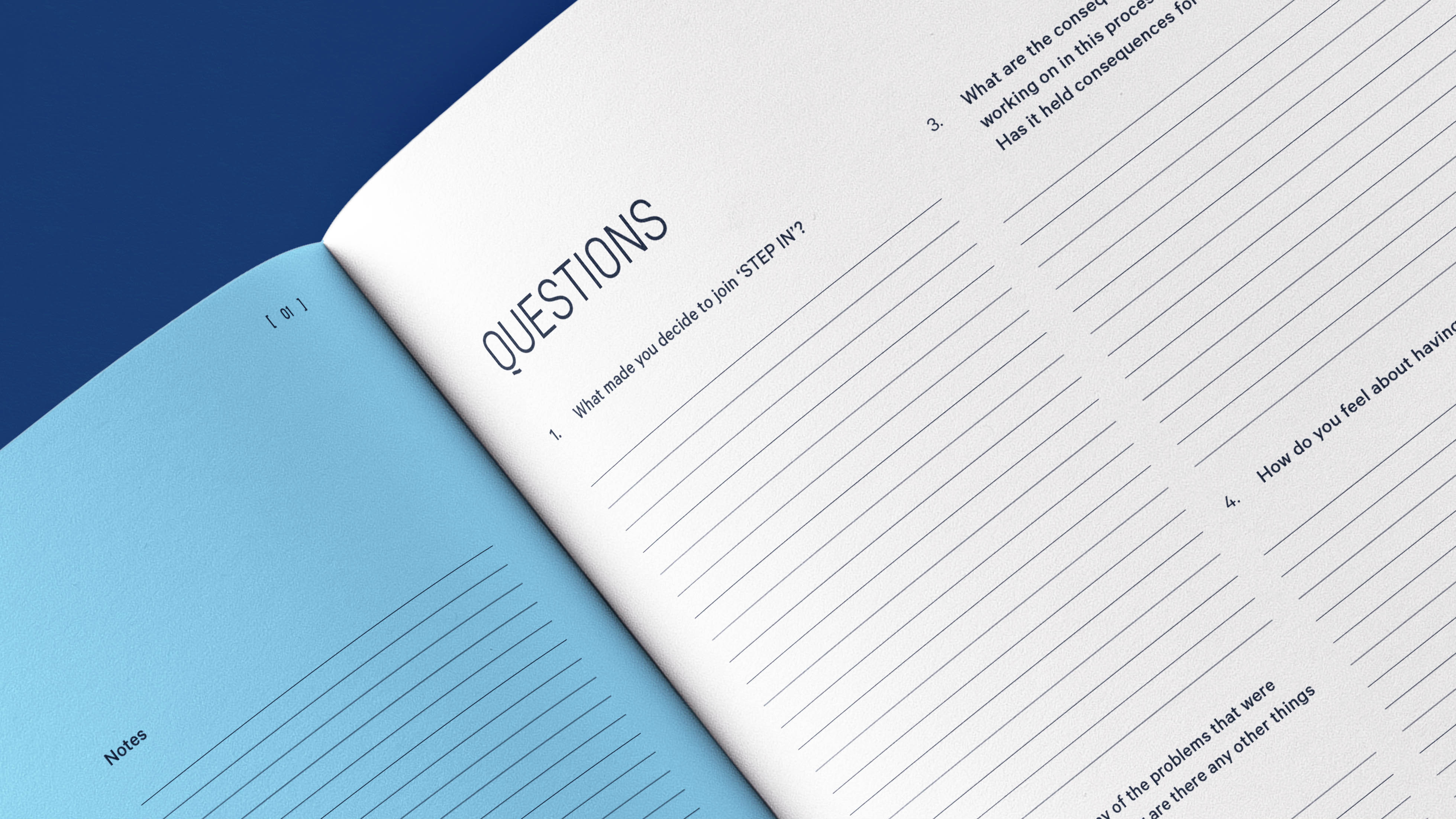 Open notebook showing a questions page with lined spaces for writing answers and a blue notes page on the left.