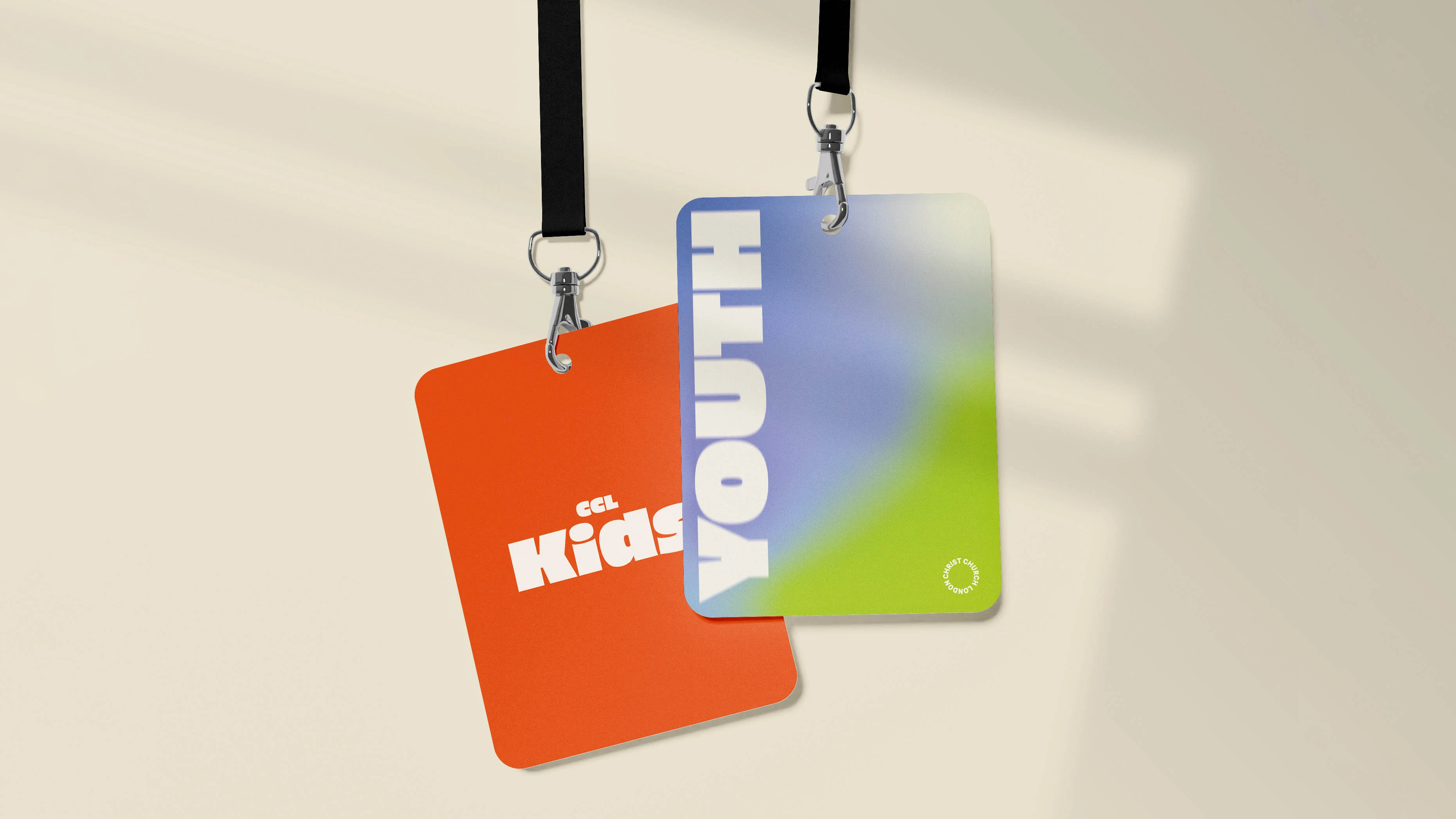 Two hanging lanyard ID cards, one orange with 'Kids' text, the other blue-green with 'YOUTH' text.