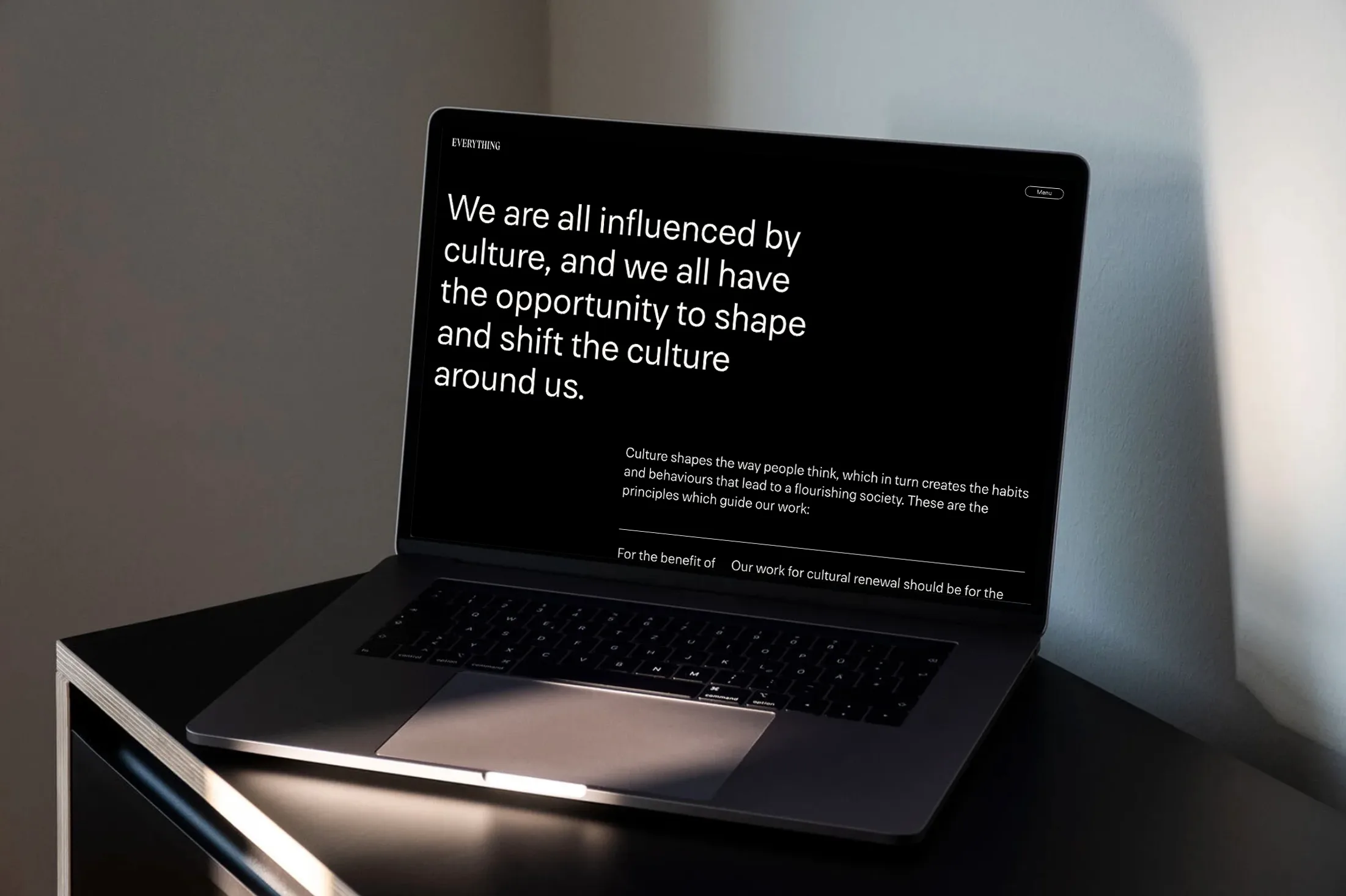 Laptop on table displaying text about culture shaping society and influencing behavior.