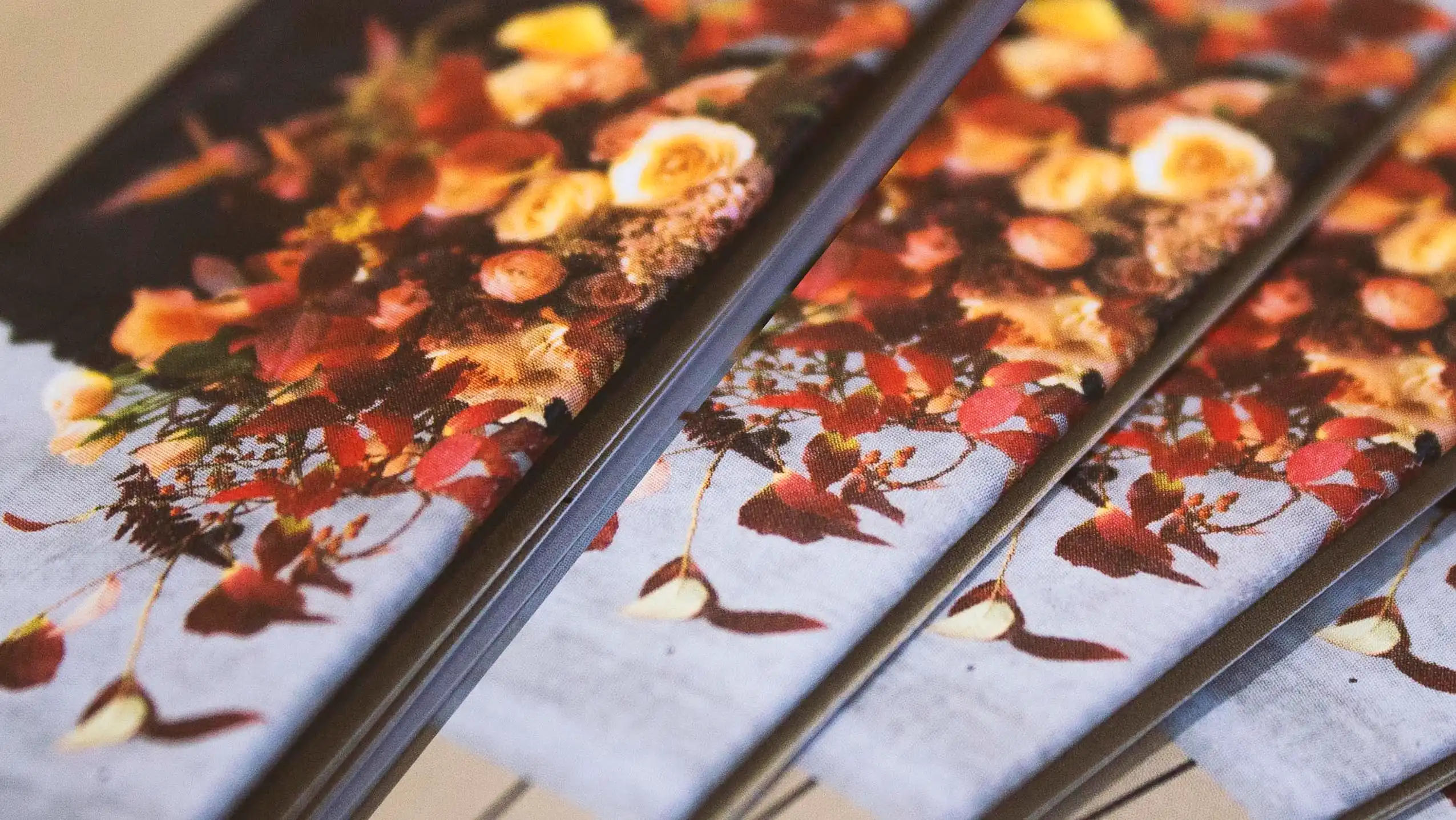 Close-up of printed fabric featuring orange, red, and cream floral designs.