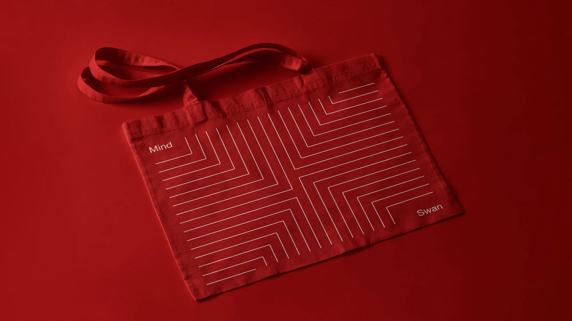 Red tote bag with white geometric line pattern and the words 'Mind' and 'Swan' printed on it.