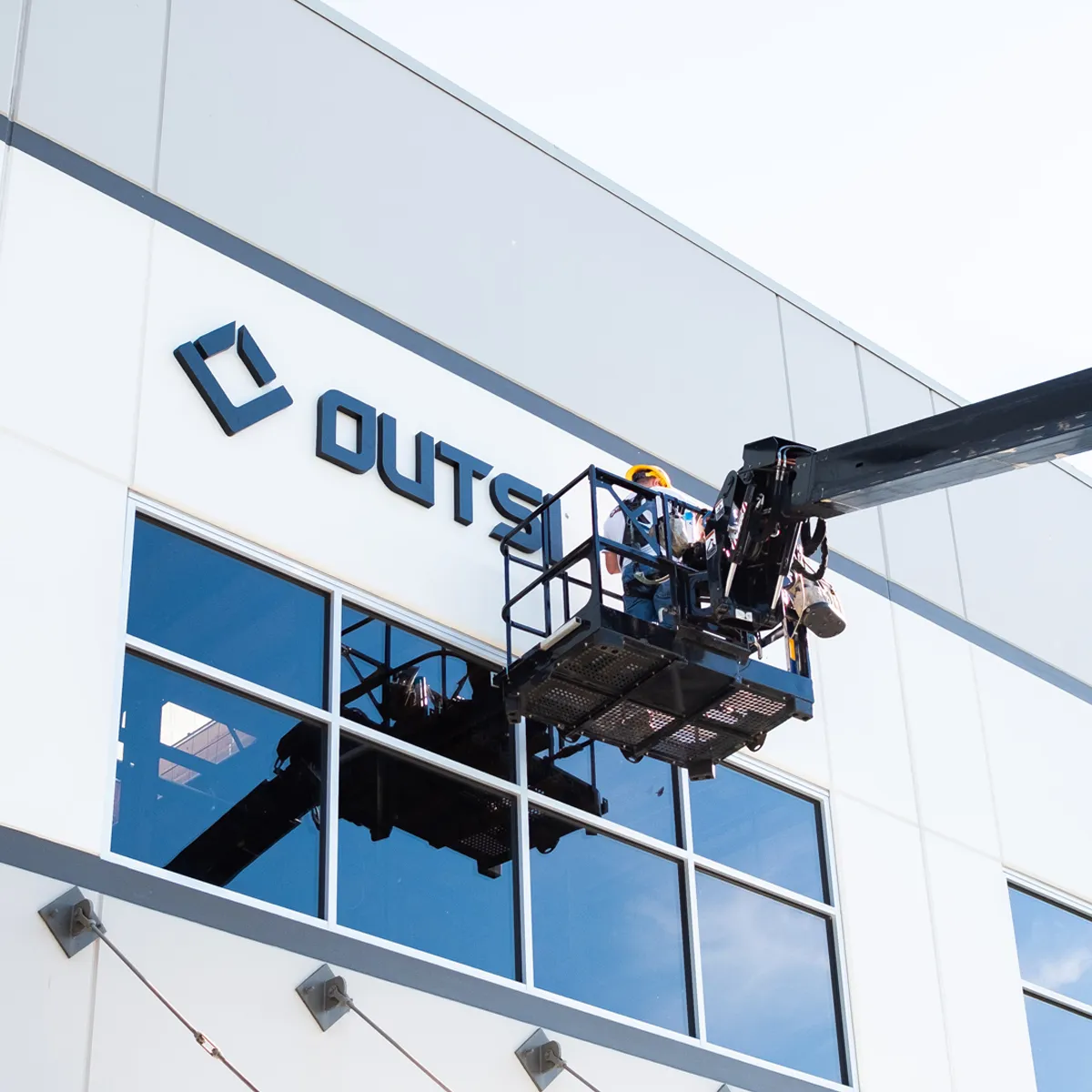 Infinity Images employee installing exterior signage