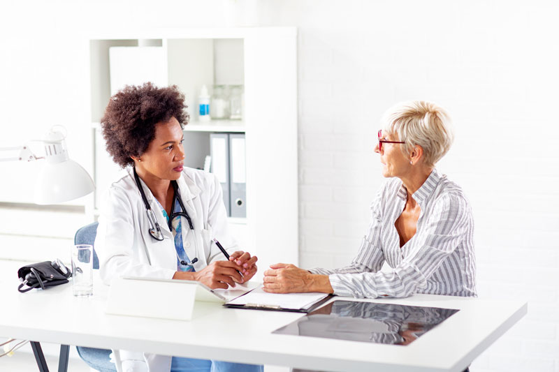 Imagem exemplificando uma médica conversando com uma paciente