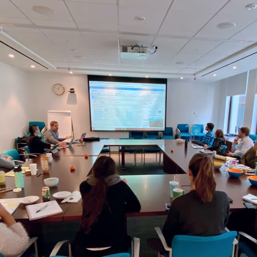Image of team in meeting room viewing projector screen
