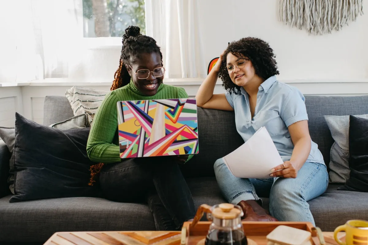 a couple of women sitting on top of a couch