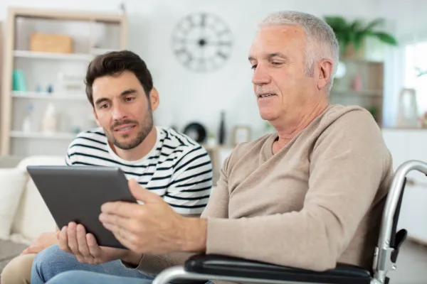 a man in a wheelchair looking at a tablet