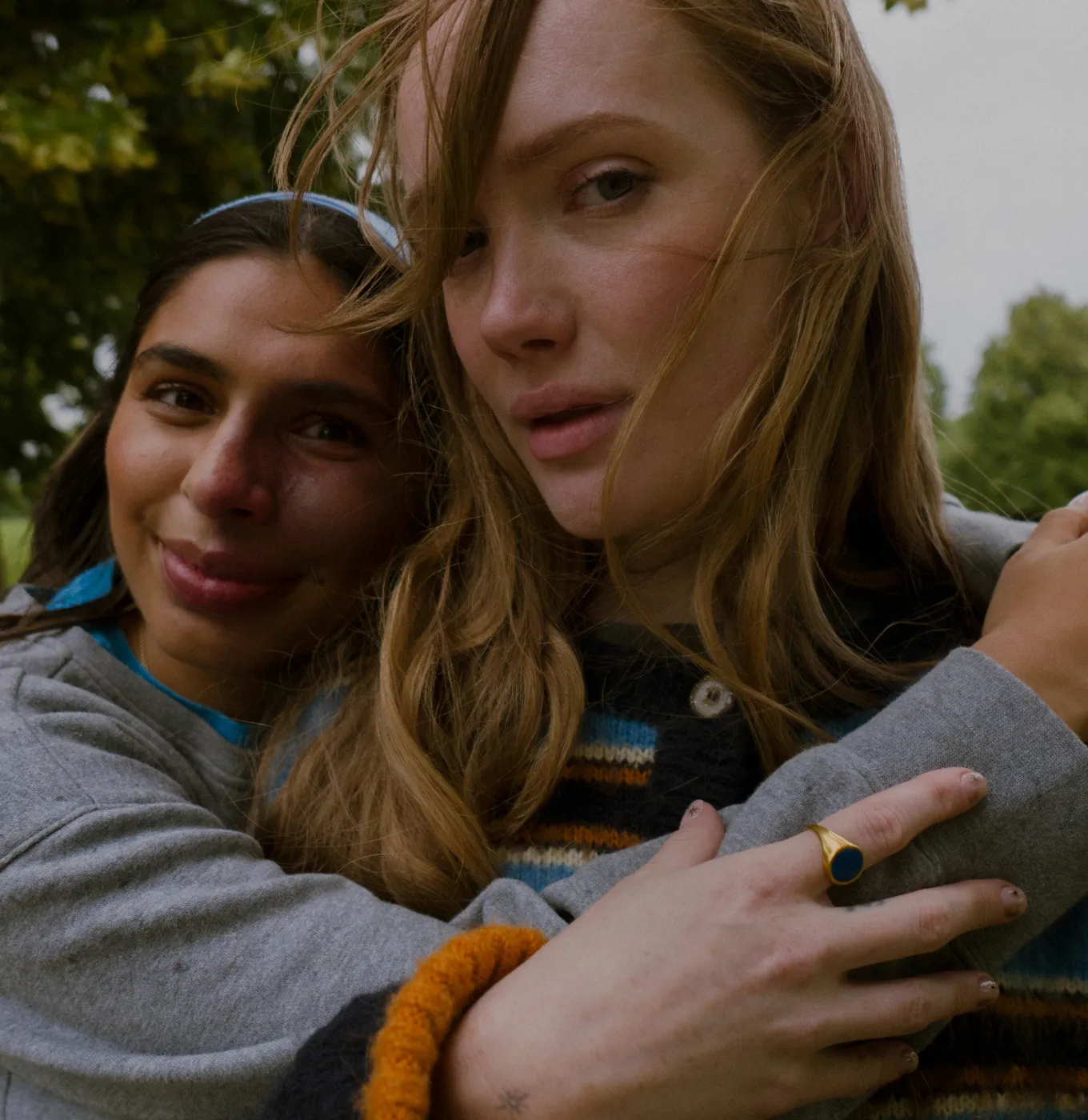 Two women hugging each other in a park.