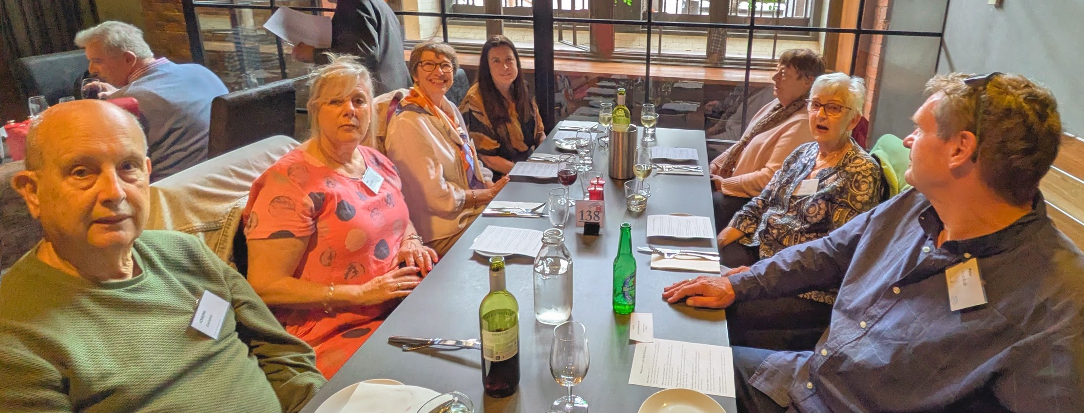 Members of ANZ Retired Officers Club sitting down smiling at camera