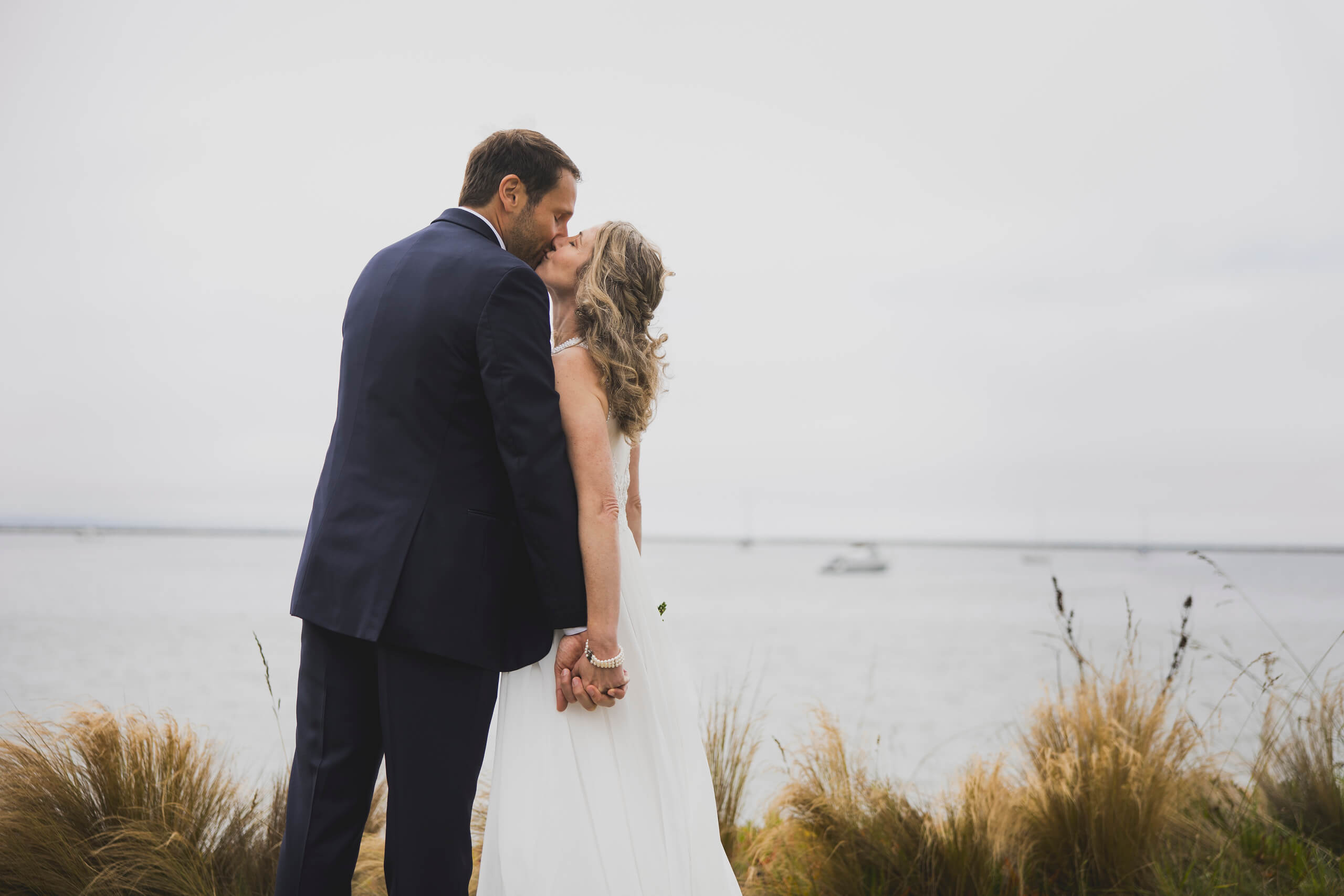 Couple kissing and holding hands by the ocean (Carla, DateSpot's Founder, and her husband Greg)