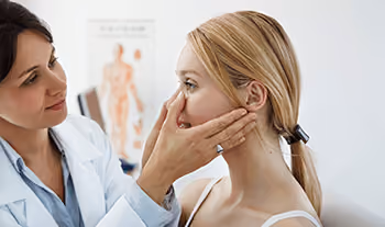 Doctor inspecting patient for sinus pain and pressure.
