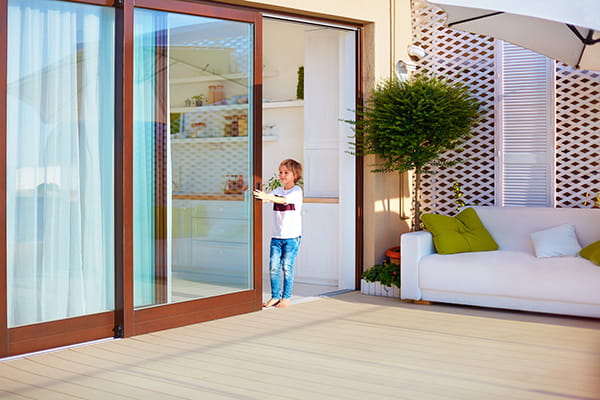 Young boy closing sliding glass door
