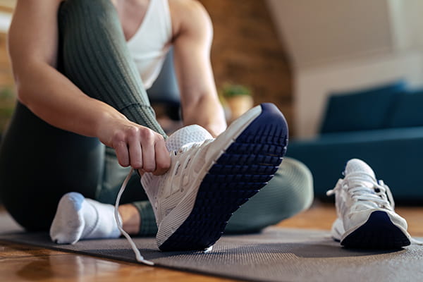 Woman putting on running shoes