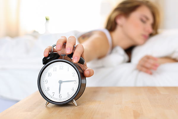 woman stopping alarm clock