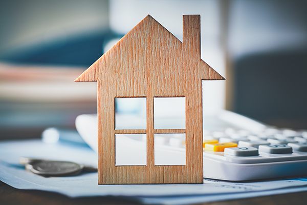 small wooden house standing in front of a calculator