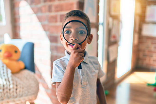 young boys with magnifying glass