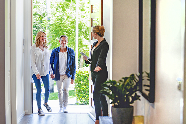 Young couple with real estate agent at home viewing