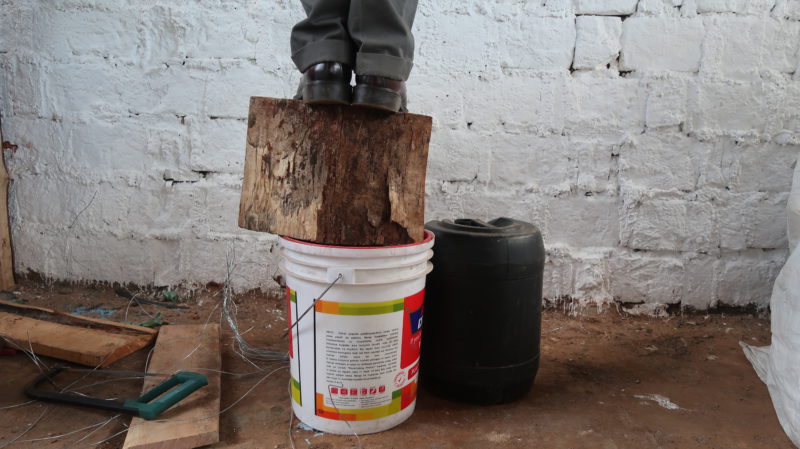 man standing on top of a bucket 