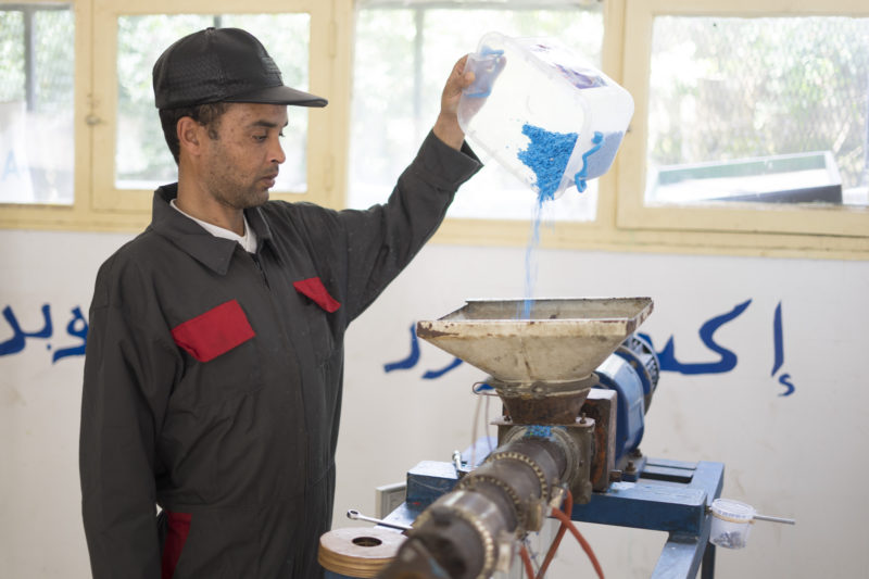 pouring plastic into extrusion machine