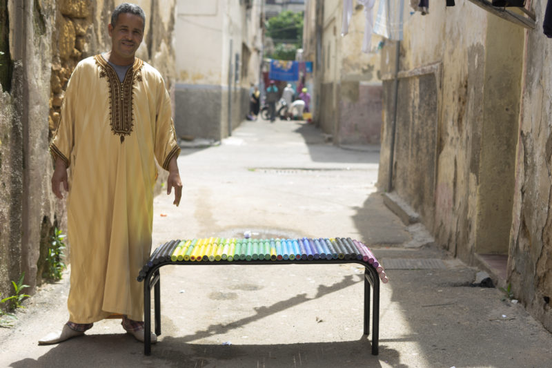 man next to a plastic bench