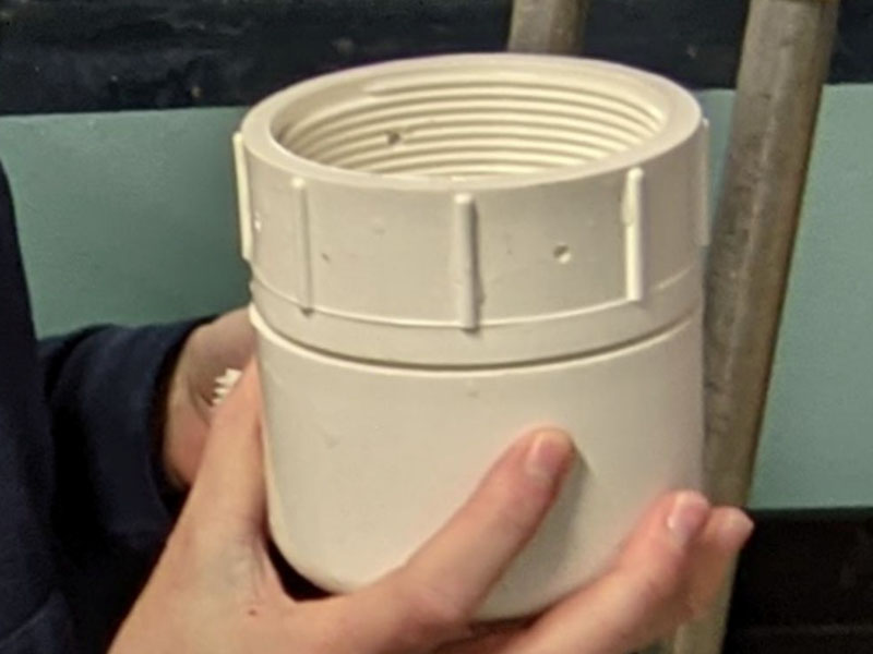 A white prototype made of PVC. It is roughly the size and shape of a wine tumbler.