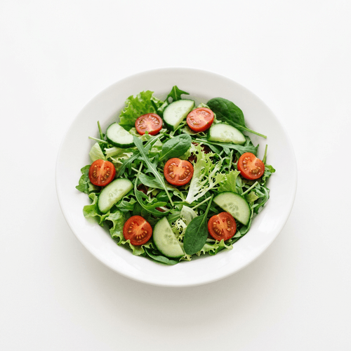 A bowl of green salad with cucumber and cherry tomatoes