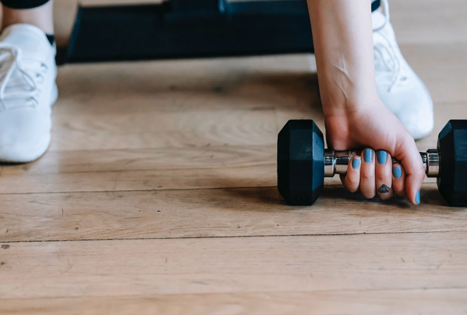 A woman’s hand lifting a dumbbell