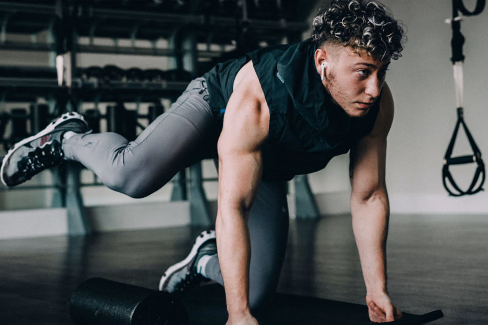 A muscular man performs a leg workout while on all fours