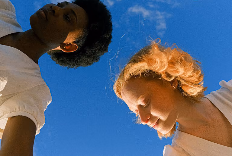 Two women against a sky backdrop