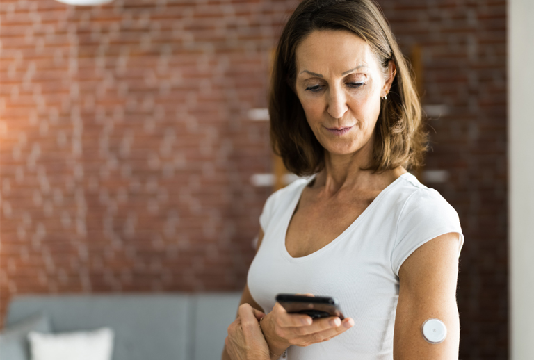 Woman checking her glucose data on her phone