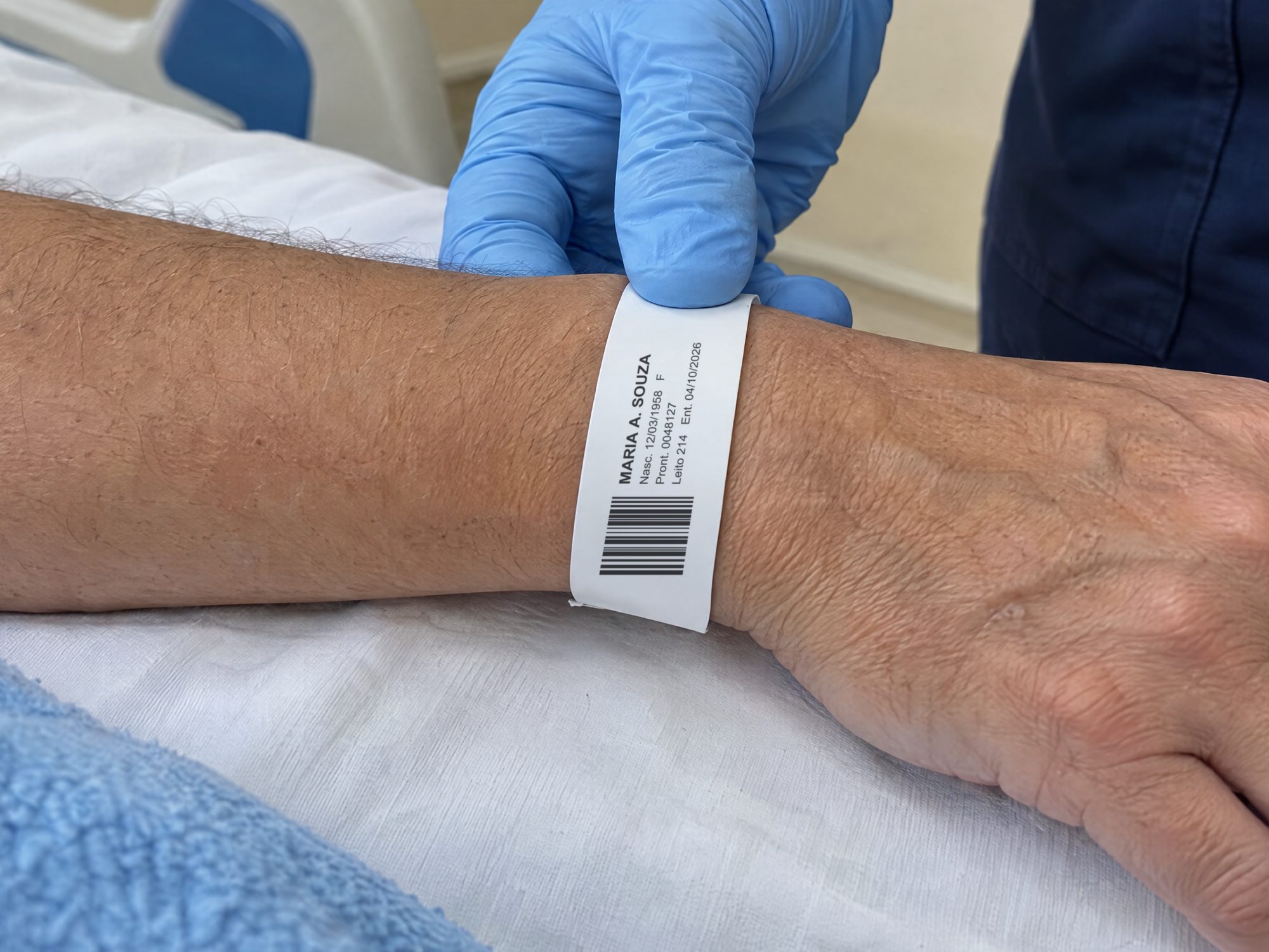 Enfermeira confere a pulseira de identificação impressa no pulso de uma paciente