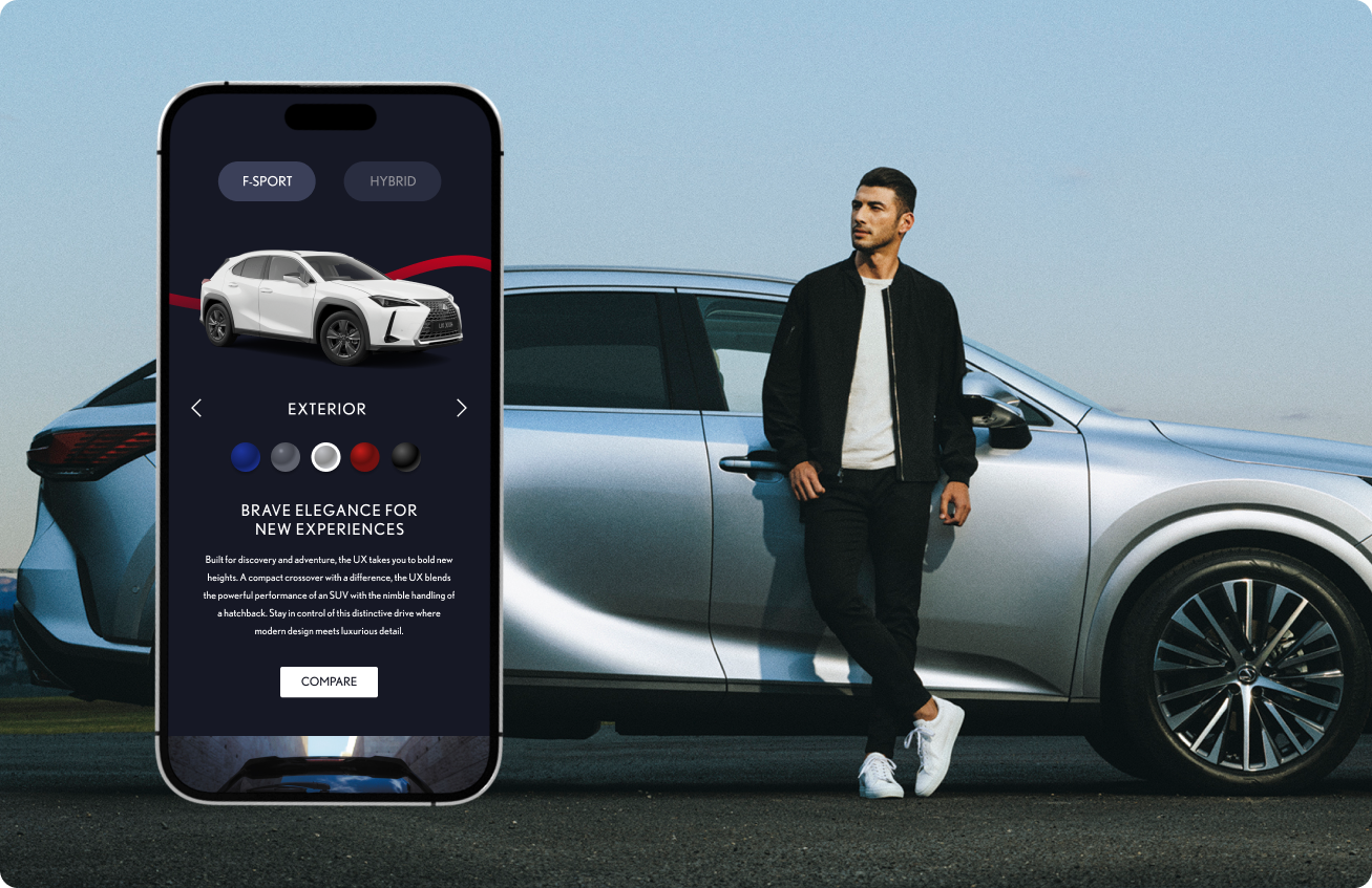 Man dressed in black jacket, white shirt, black pants, and white shoes leaning against a silver luxury SUV on a paved surface under a clear sky, with a large smartphone screen next to him showing a car customization app featuring a white SUV, exterior color options, and description text about the vehicle's bold and elegant design and performance.