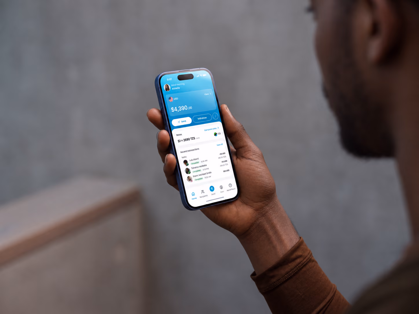 Hand holding a phone showing a NALA USD account balance