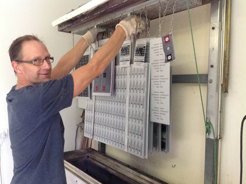 A Metal Sign & Label staff member working in the asset tags and labels manufacturing facility