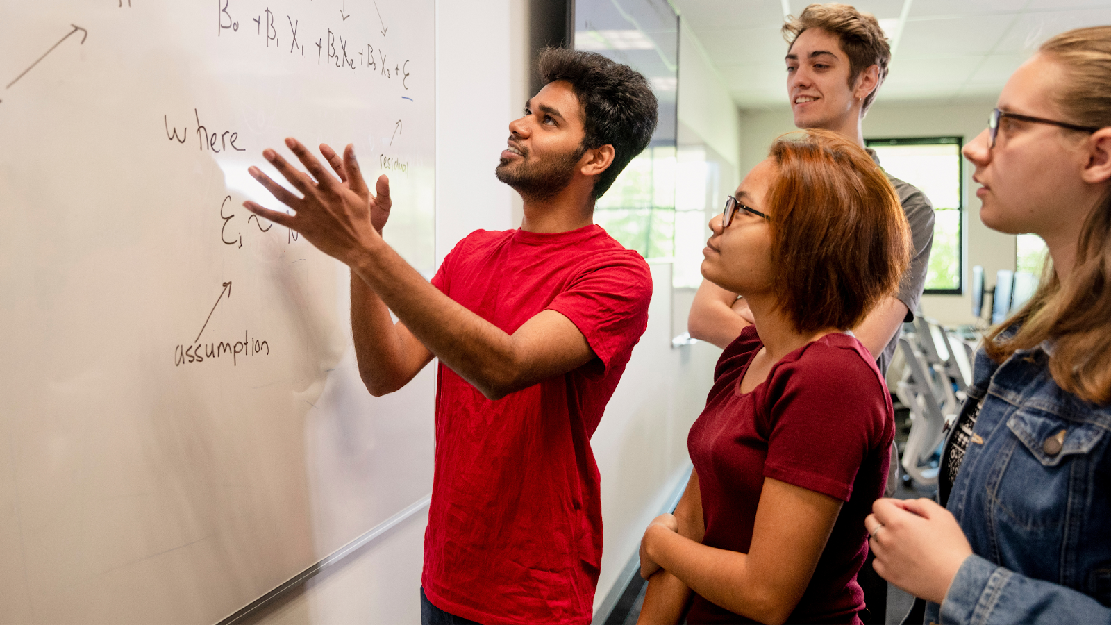 Team collaborating at a whiteboard during a problem-solving workshop to develop business solutions.