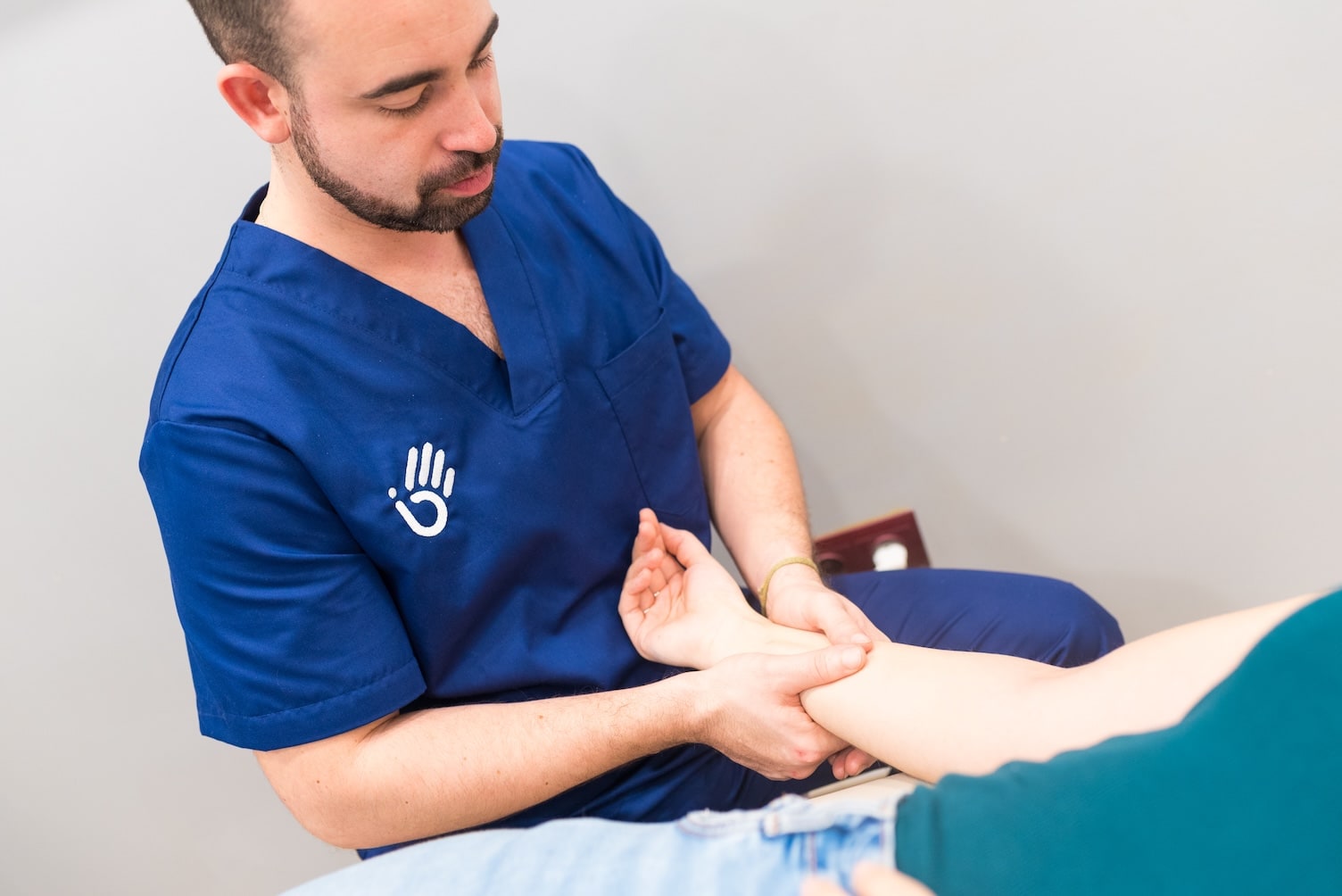Fisioterapeuta aplicando drenaje linfático manual en consulta