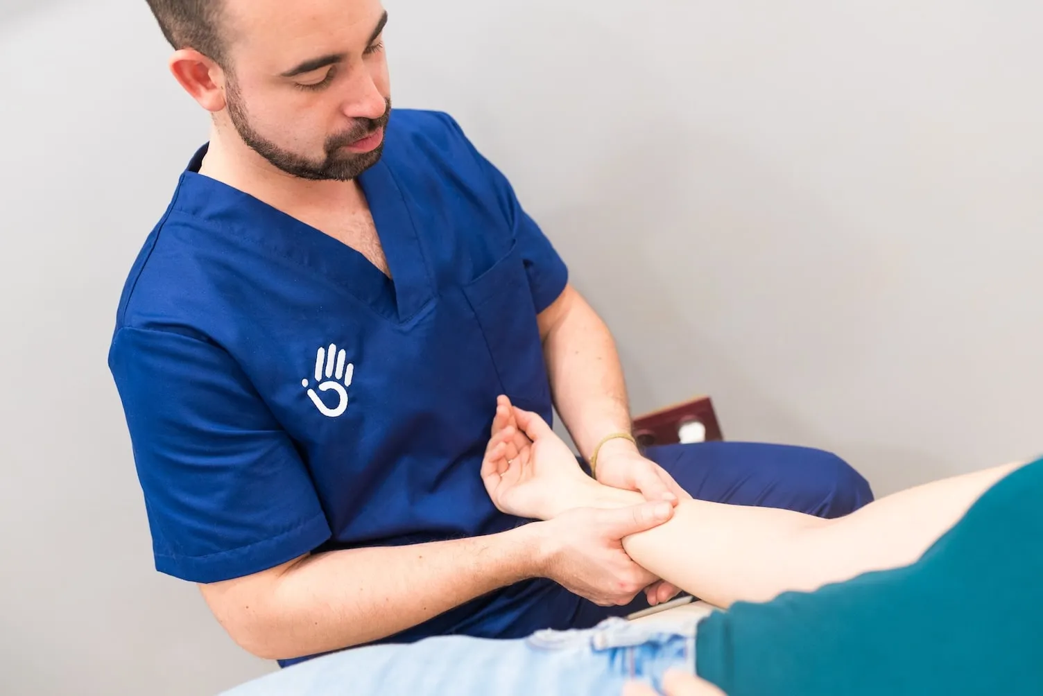 Fisioterapeuta aplicando drenaje linfático manual en consulta